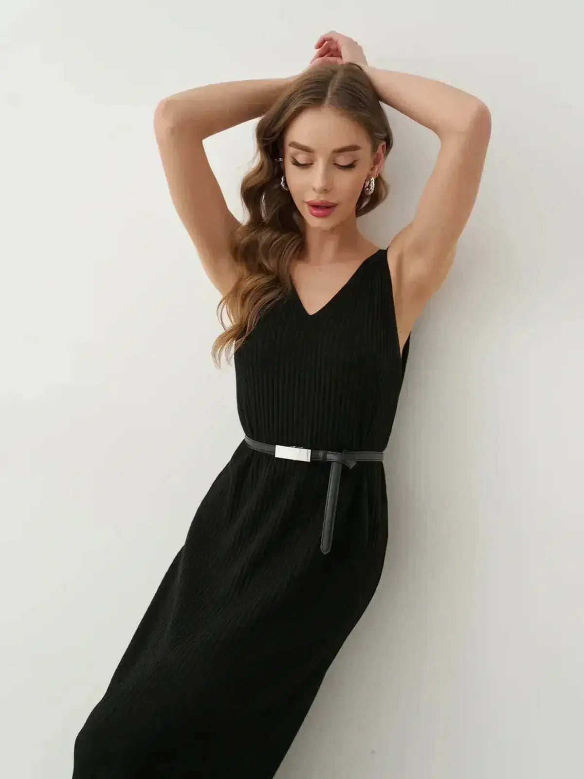 Model wearing a black Muse Knit Maxi Dress, showcasing its elegant V-neckline and sleek silhouette.