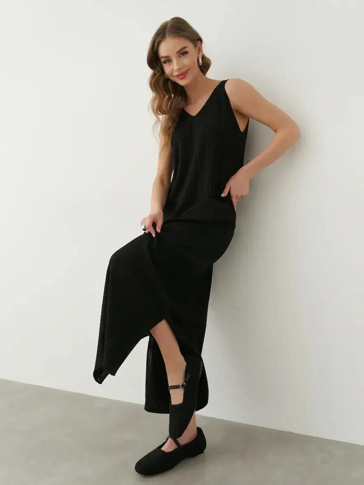 Model showcasing the Muse Knit Maxi Dress in black, featuring a V-neckline and side slit for elegant movement.