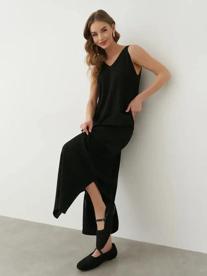 Model showcasing the Muse Knit Maxi Dress in black, featuring a V-neckline and side slit for elegant movement.