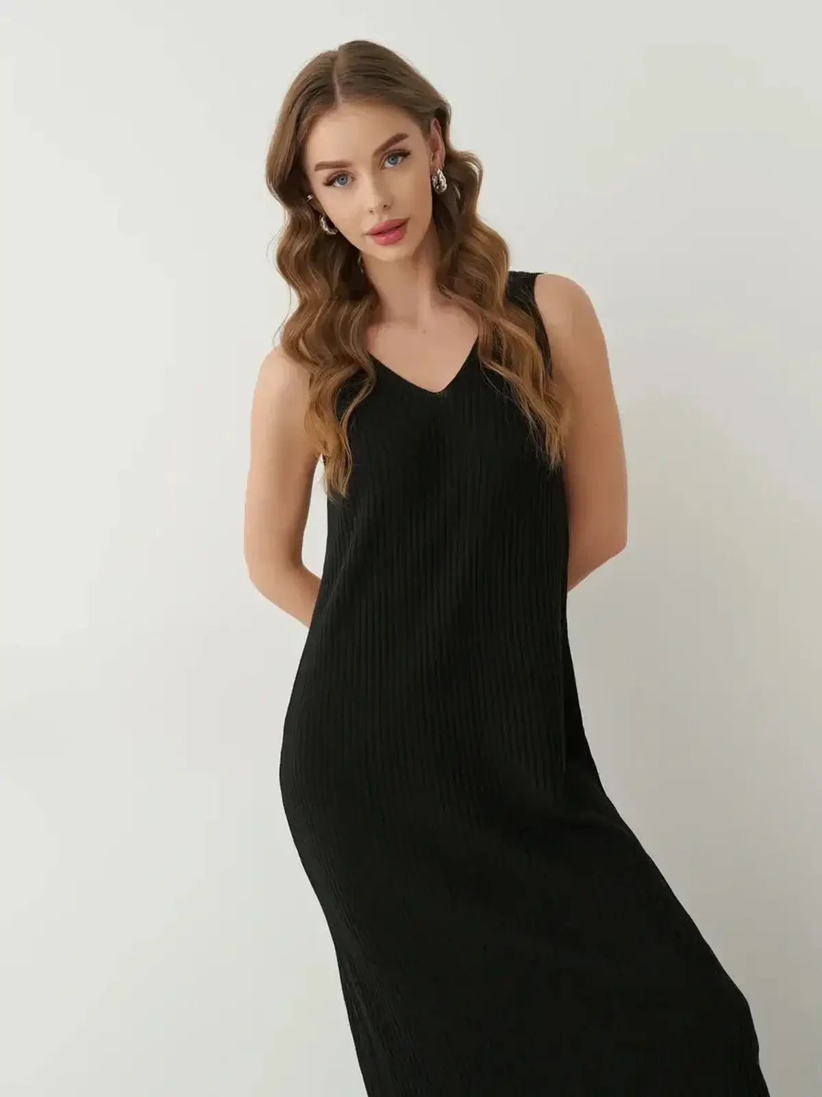 Model wearing the Muse Knit Maxi Dress in black, showcasing its sleek design and elegant V-neckline.