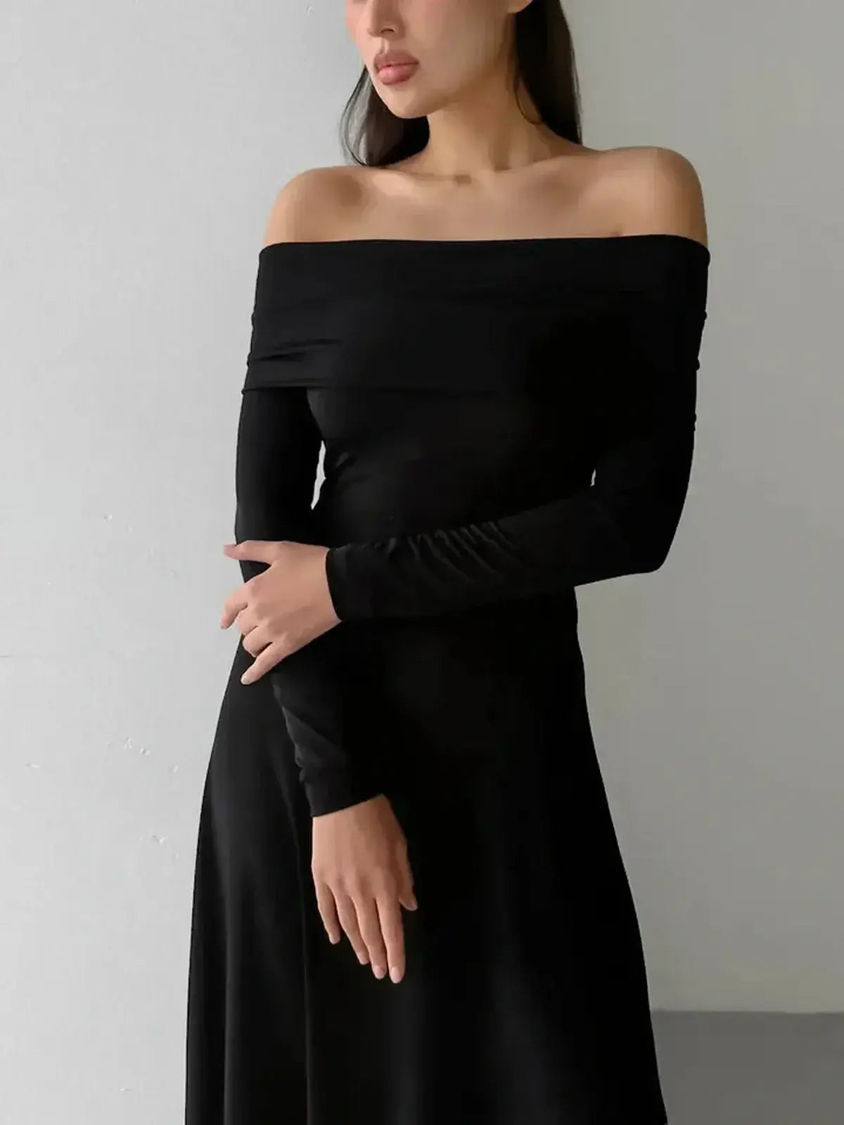 Muse Maxi Dress model wearing sleek off-shoulder dress with sculpting fit and full-length skirt.