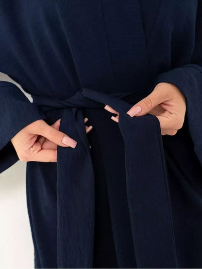 Navy Suit Set by Lauven featuring a model tying the waist belt of the stylish oversized two-piece set.