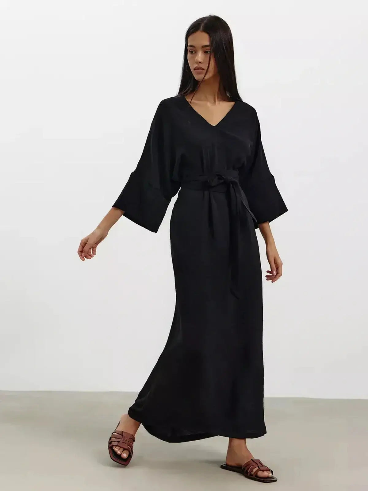Model wearing the Noir Drift Maxi Dress featuring a V-neckline, kimono sleeves, and a cinched waist, exuding elegance.
