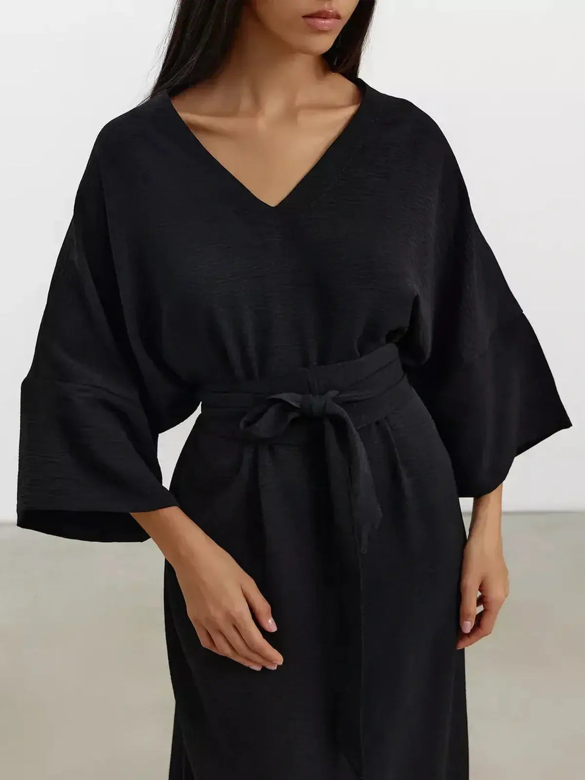 Noir Drift Maxi Dress with kimono sleeves and V-neckline, featuring a sculpted belt for a stylish silhouette.
