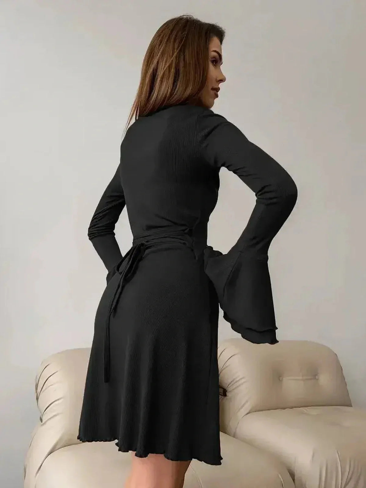 Elegant black mini dress with flared cuffs and sculpting tie waist, perfect for weddings or special occasions.