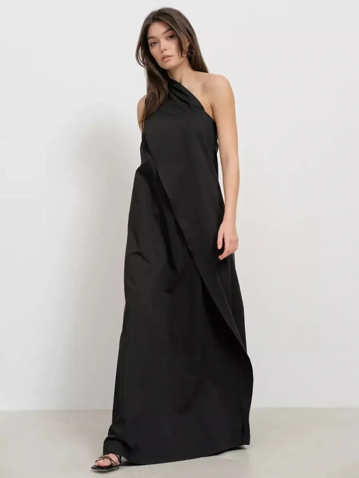 Noir Fold Maxi Dress featuring a one-shoulder silhouette and structured drape, perfect for elegant evening occasions.