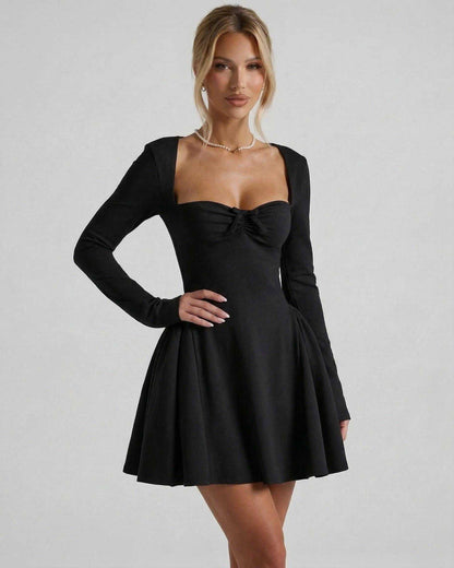 Noir Mini Dress by Lauven featuring long sleeves, square neckline, ruched bow detail, and flattering fit-and-flare silhouette.