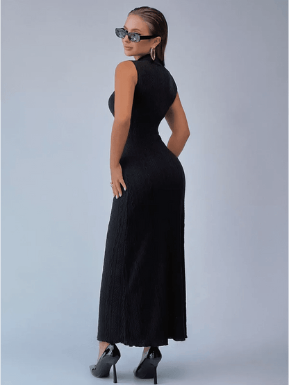 Woman wearing a sleek black Noir Sculpt Maxi Dress with modern elegance, showcasing a fitted silhouette and high-neck design.