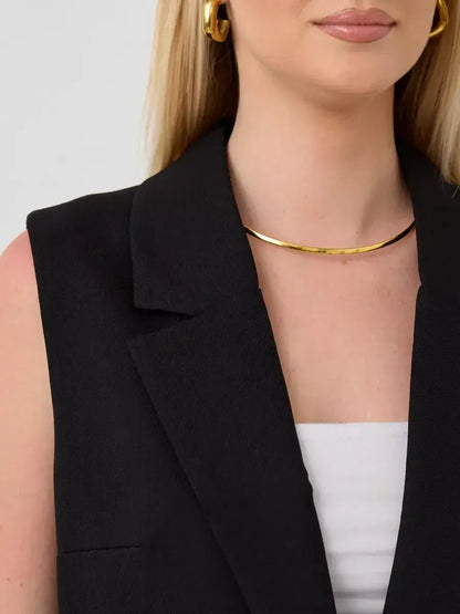 Close-up of a woman wearing the Noir Suit Set by Lauven, featuring a sleeveless black vest and elegant jewelry.