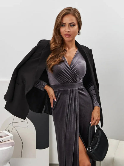 Elegant woman in Noir Whisper Maxi Dress, showcasing velvety graphite fabric and a dramatic thigh-high slit.