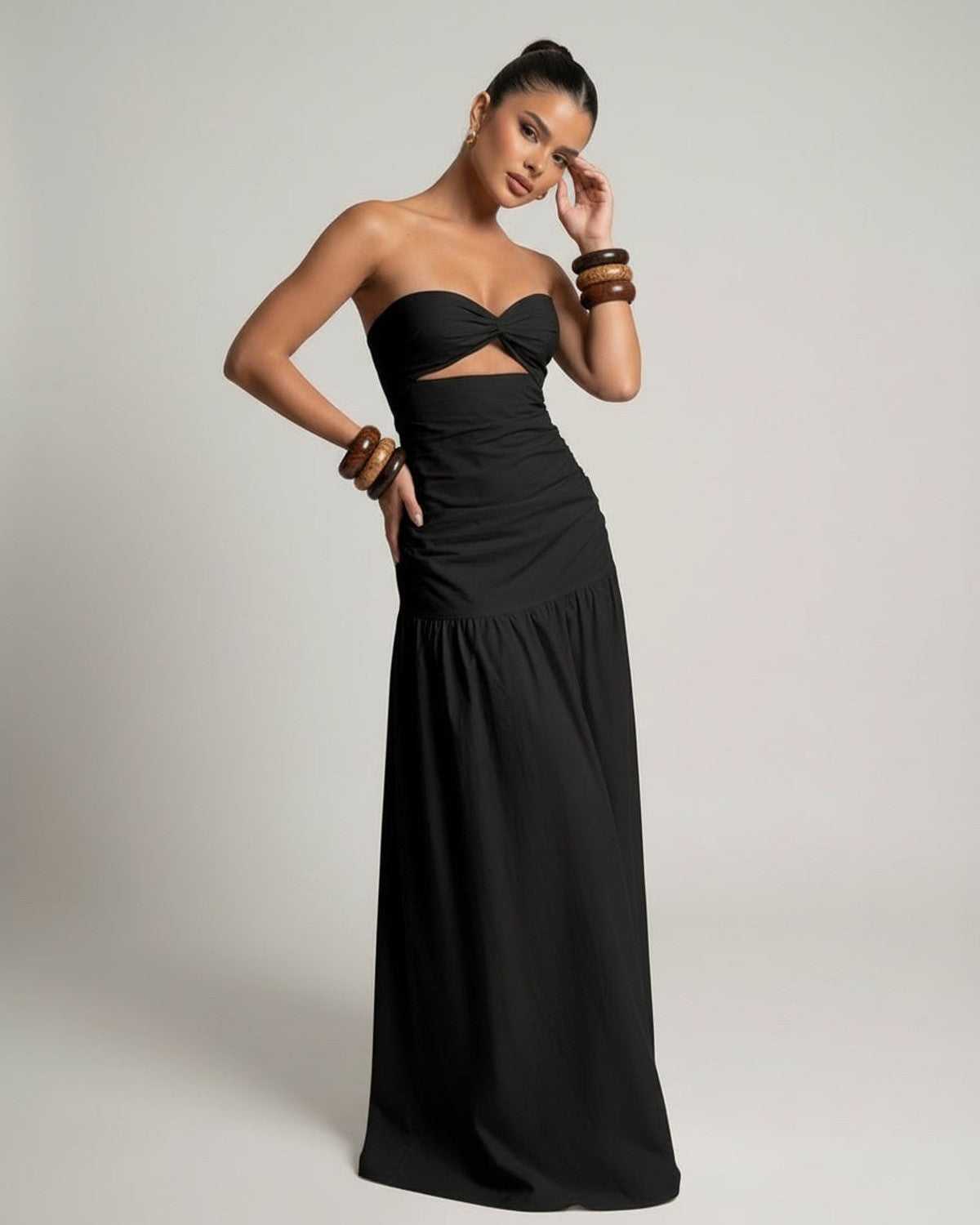 Noira Maxi Dress featuring a black strapless design and cutout high waist silhouette by Lauven, offering an elegant and modern look.