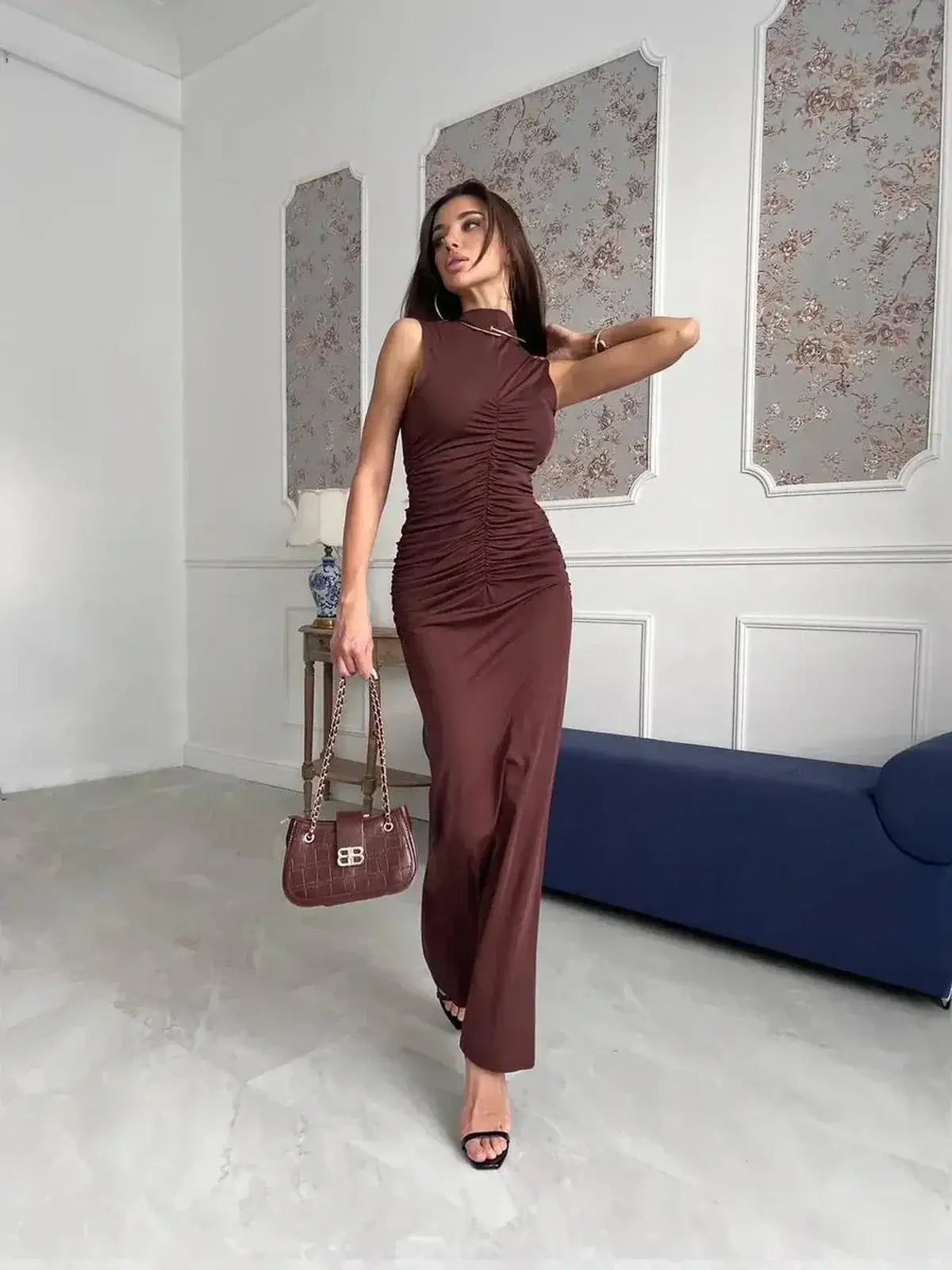 Model showcasing the Noircocoa Maxi Dress in chocolate, highlighting its sleek silhouette and ruching details.