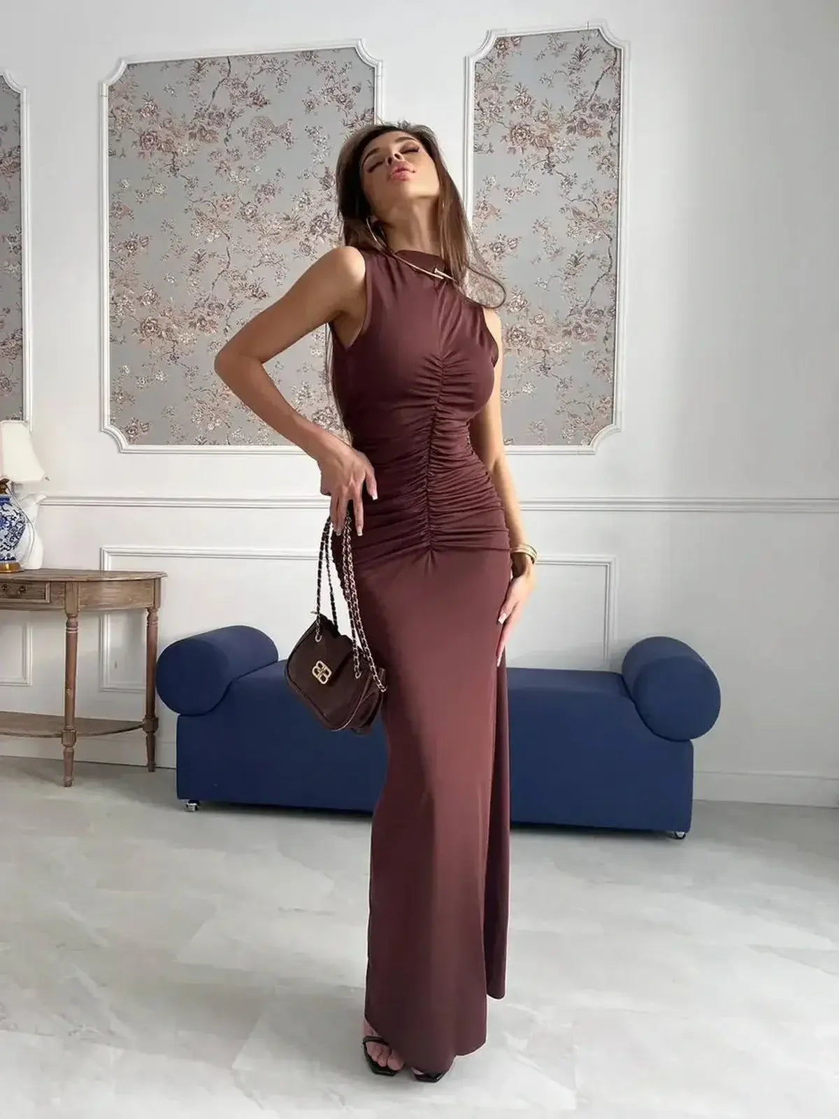 Model showcasing Noircocoa Maxi Dress in chocolate, featuring draped silhouette and sculptural ruching, perfect for elegant occasions.