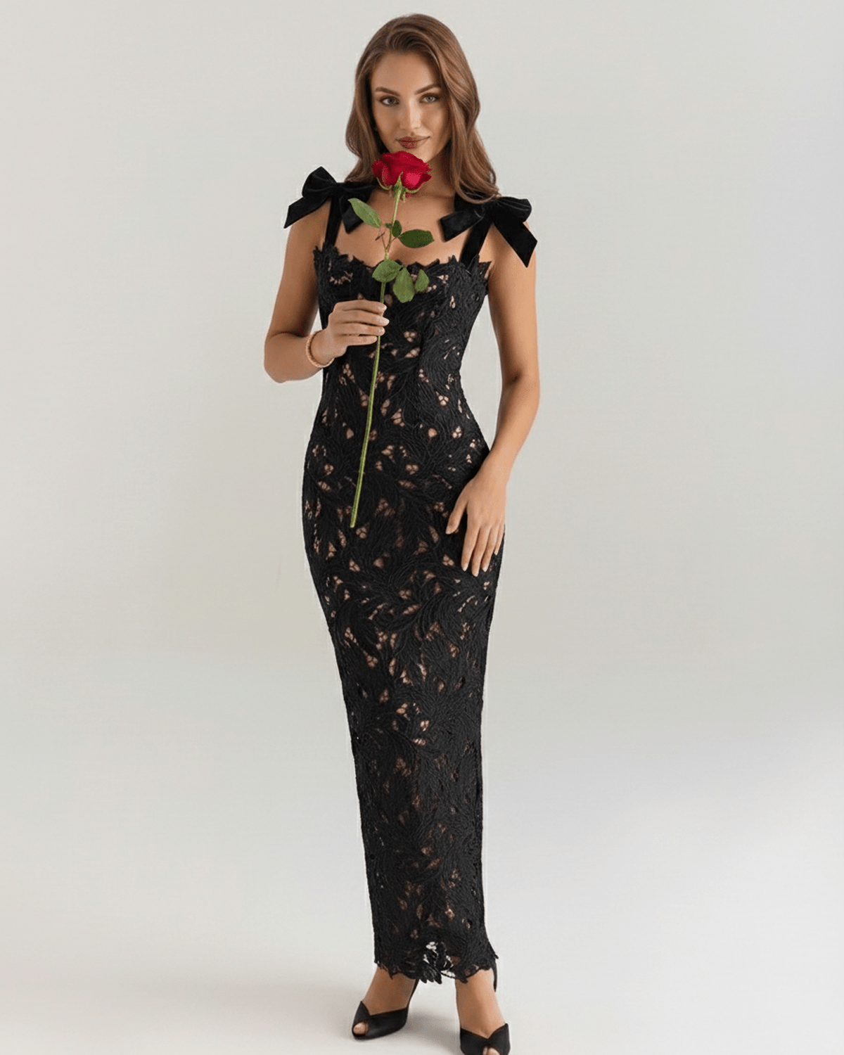 Model wearing Noirelle Maxi Dress, a black lace maxi dress with a square neck and shoulder ties, exuding elegance.