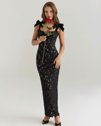 Model wearing Noirelle Maxi Dress, a black lace maxi dress with a square neck and shoulder ties, exuding elegance.