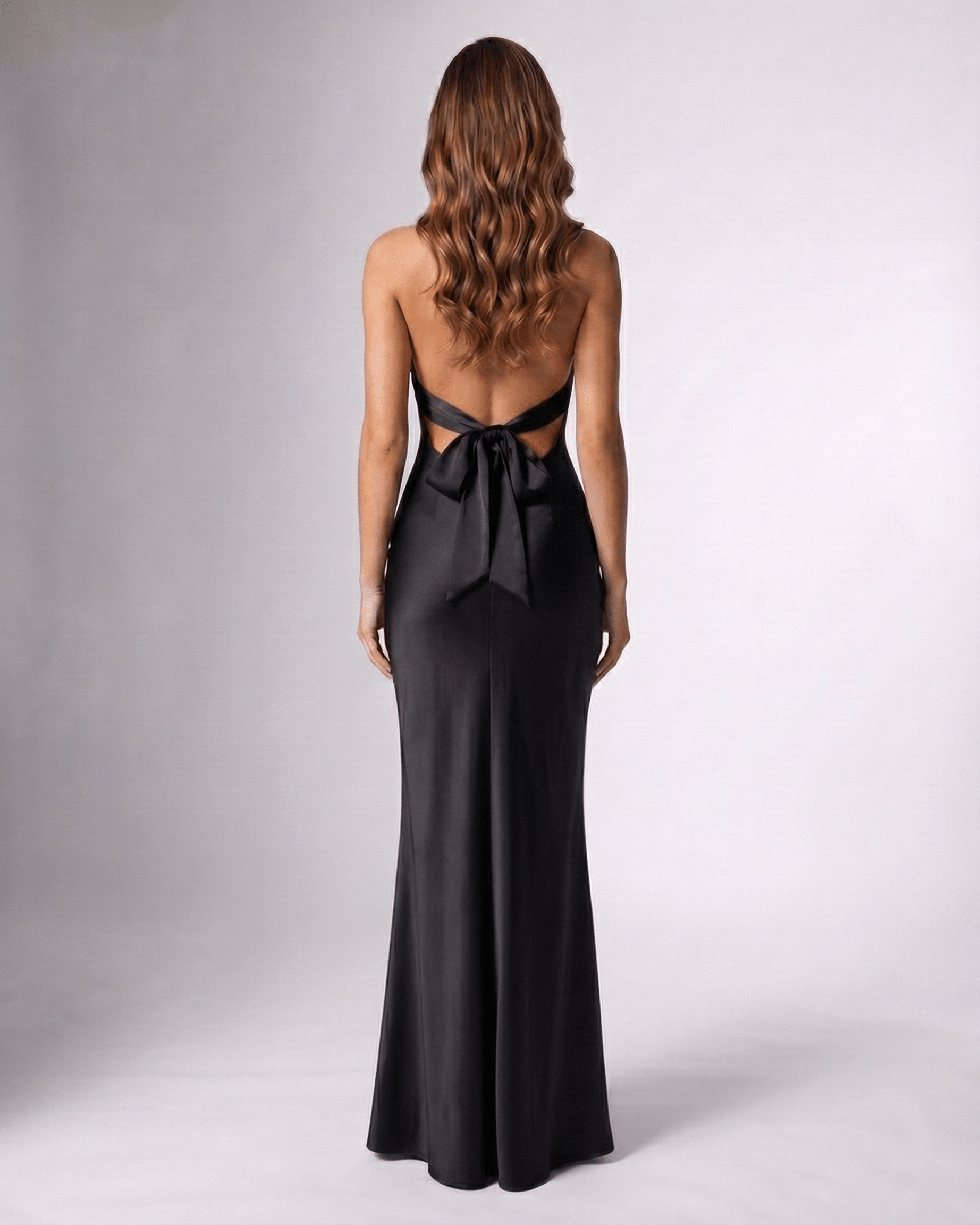 Noirise Maxi Dress back view, black satin maxi dress with halter neck and bow detail by Lauven.