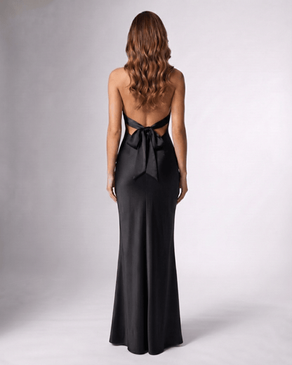 Noirise Maxi Dress back view, black satin maxi dress with halter neck and bow detail by Lauven.