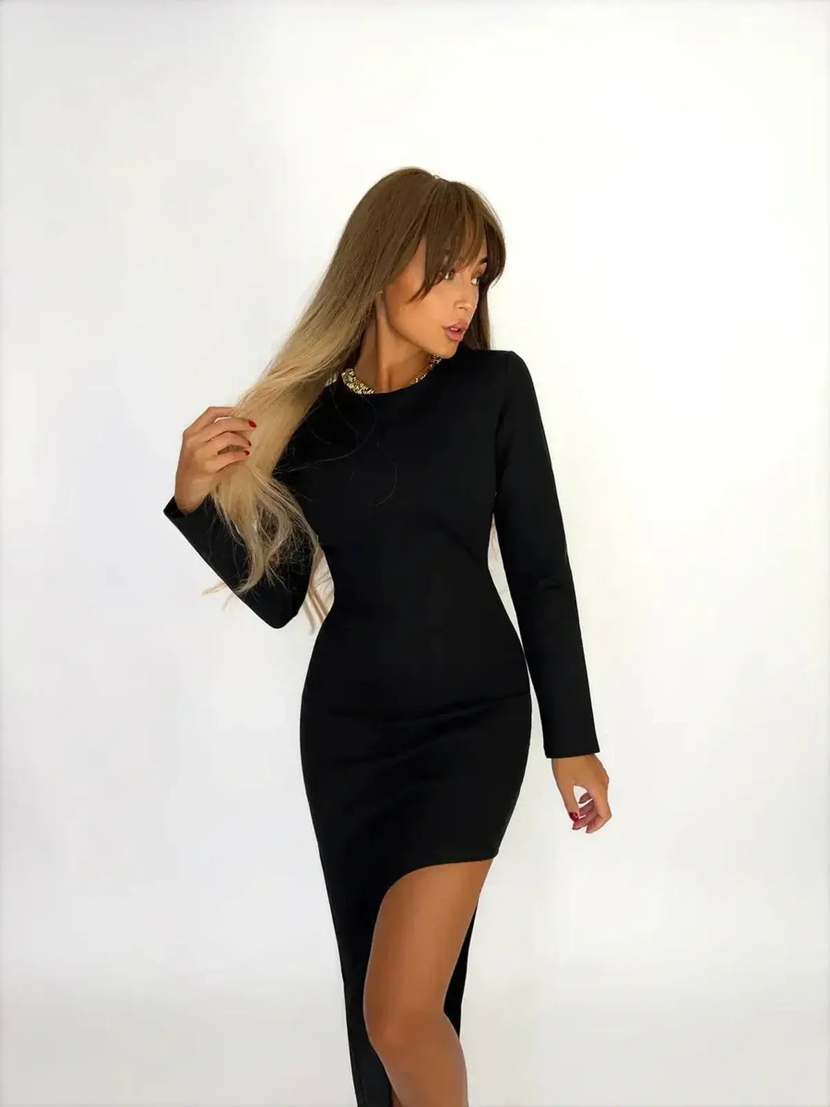 Sleek woman in a black Noirline Maxi Dress with long sleeves and a high slit, exuding elegance and modern style.