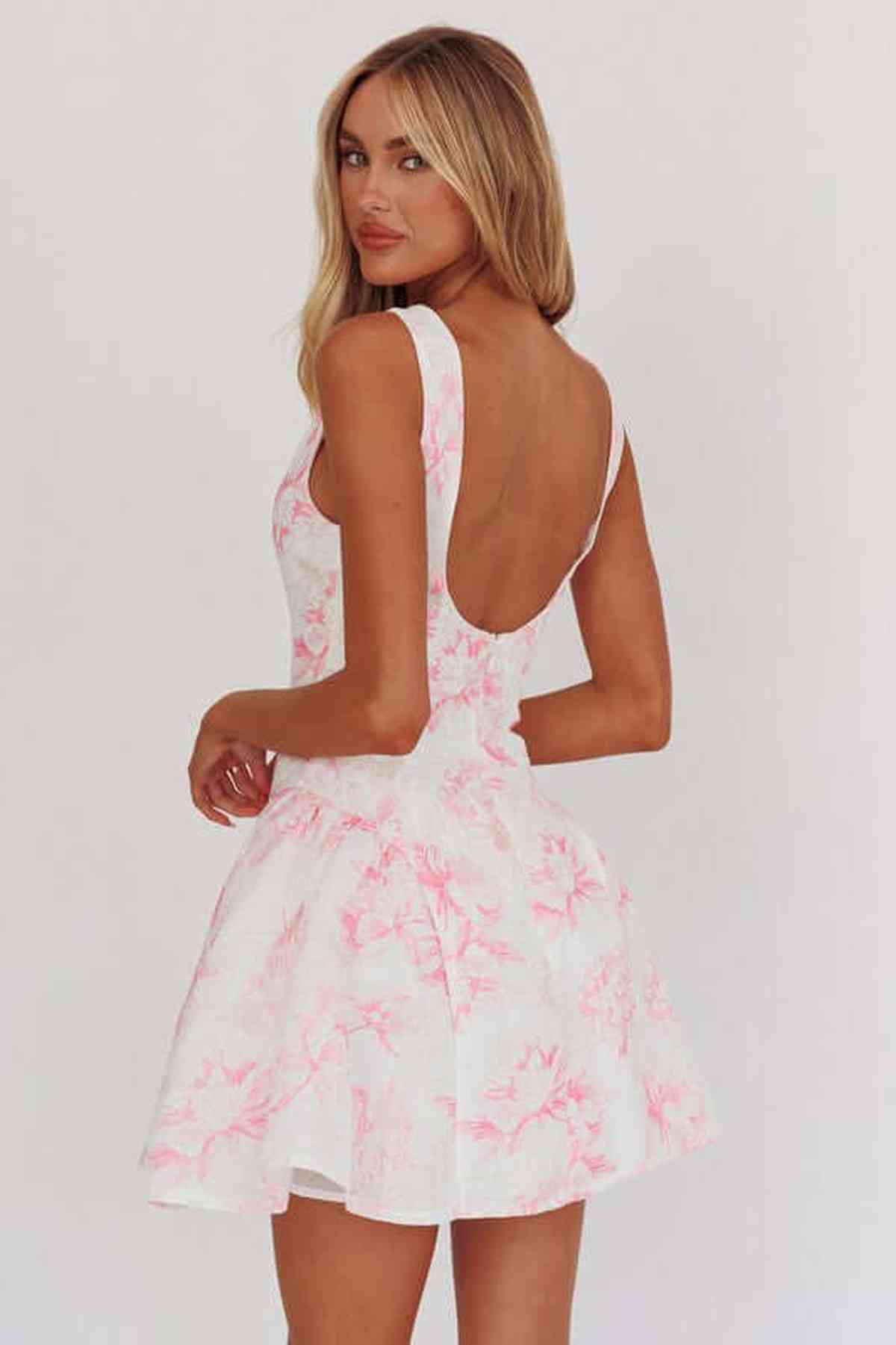 Nora Mini Dress featuring a floral design, structured bodice, and low scoop back in soft pink on white. Perfect for summer occasions.