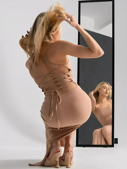 Nude lace midi dress with corset back, sculpting ribbed fit, showcasing thigh-high slit and adjustable straps in front of a mirror.
