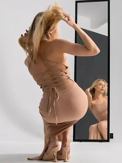 Model showcasing the Nude Lace Midi Dress by Lauven in front of a mirror, featuring a strappy corset back and thigh-high slit.