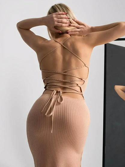 Back view of a woman in a nude lace midi dress with a corset-style lace-up back and ribbed texture.