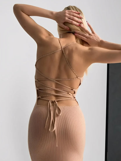 Back view of a model in a nude lace midi dress showcasing the adjustable lace-up corset design.