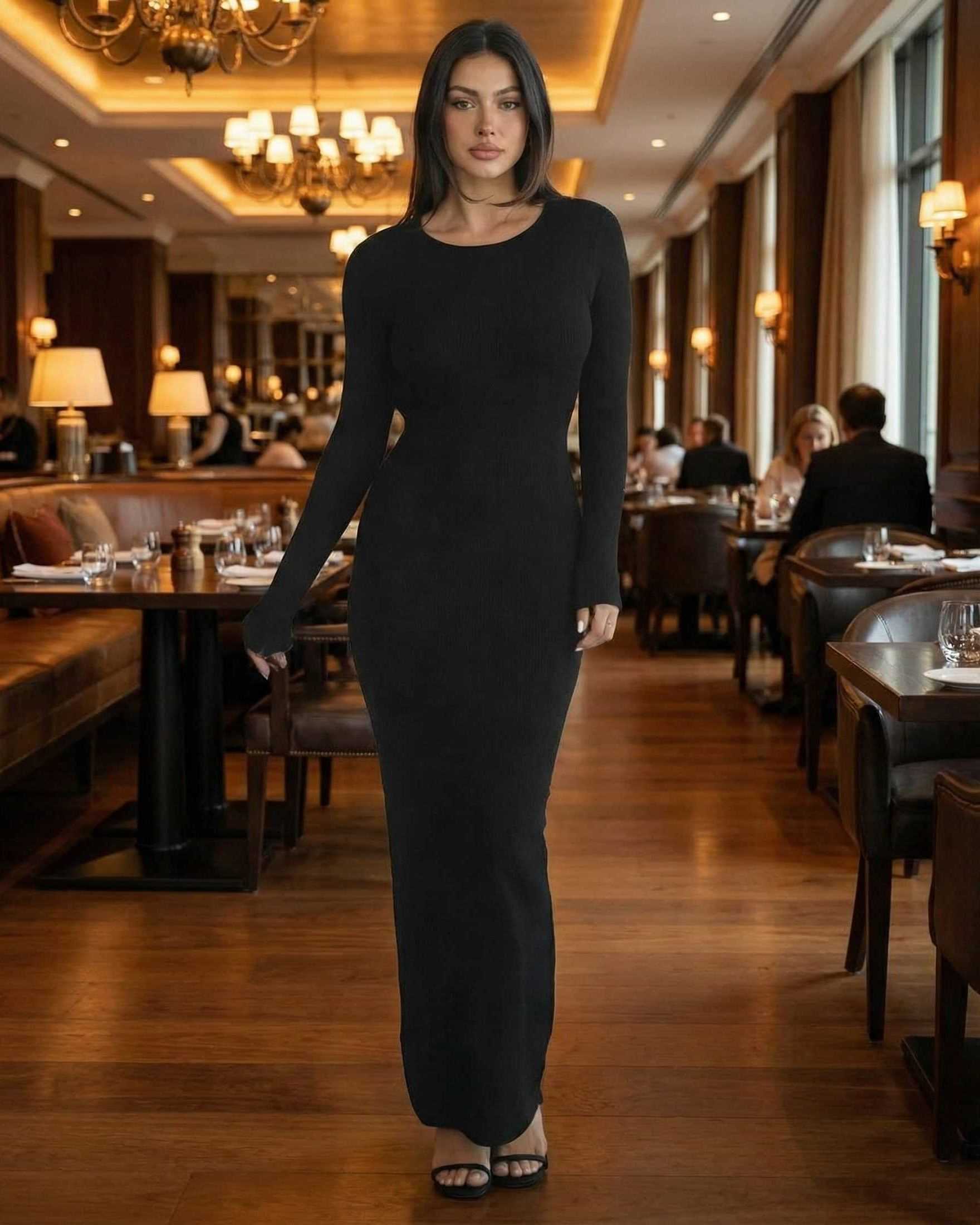Model showcasing the Nyx Maxi Dress by Lauven, a long sleeve black maxi dress with open back detail.