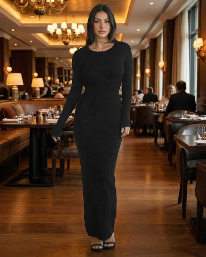 Model showcasing the Nyx Maxi Dress by Lauven, a long sleeve black maxi dress with open back detail.