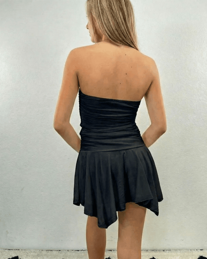 Nyx Mini Dress by Lauven - Strapless ruched mini dress with flowy hem in black, showing back view on a model.