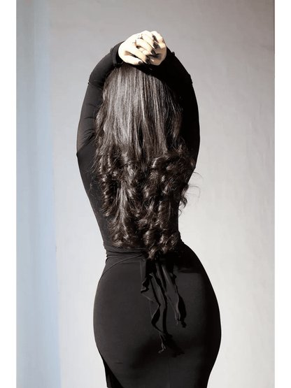 Model showcasing the back of an Obsidian Drape Maxi Dress with gathered detail and flowing hair.