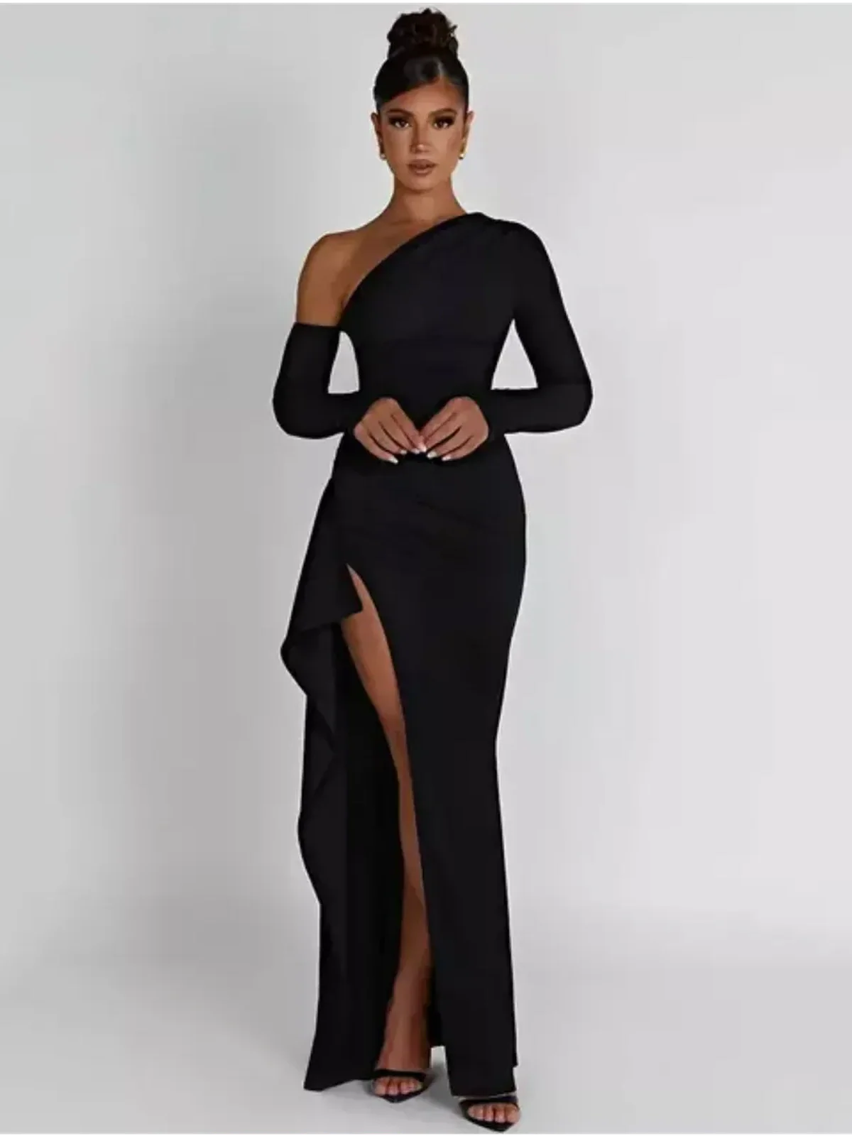 Woman wearing the Obsidian Grace Maxi Dress, featuring a daring slit and asymmetric one-shoulder design.
