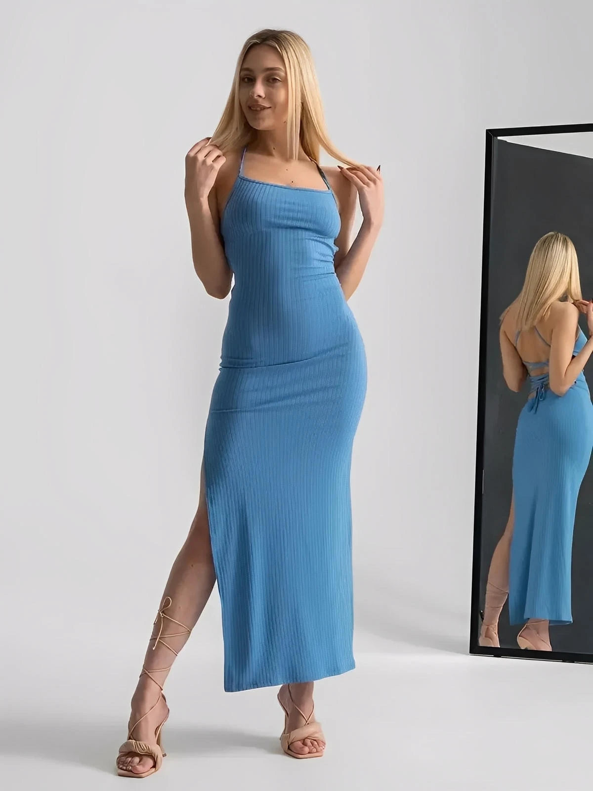 Model showcasing the Ocean Lace Midi Dress in blue, featuring a ribbed fit, side slit, and corset back.