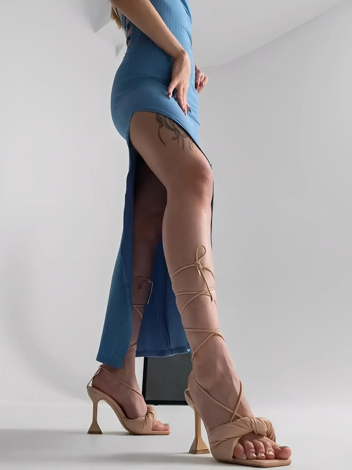 Model showcasing the Ocean Lace Midi Dress with a thigh-high slit and strappy nude heels.