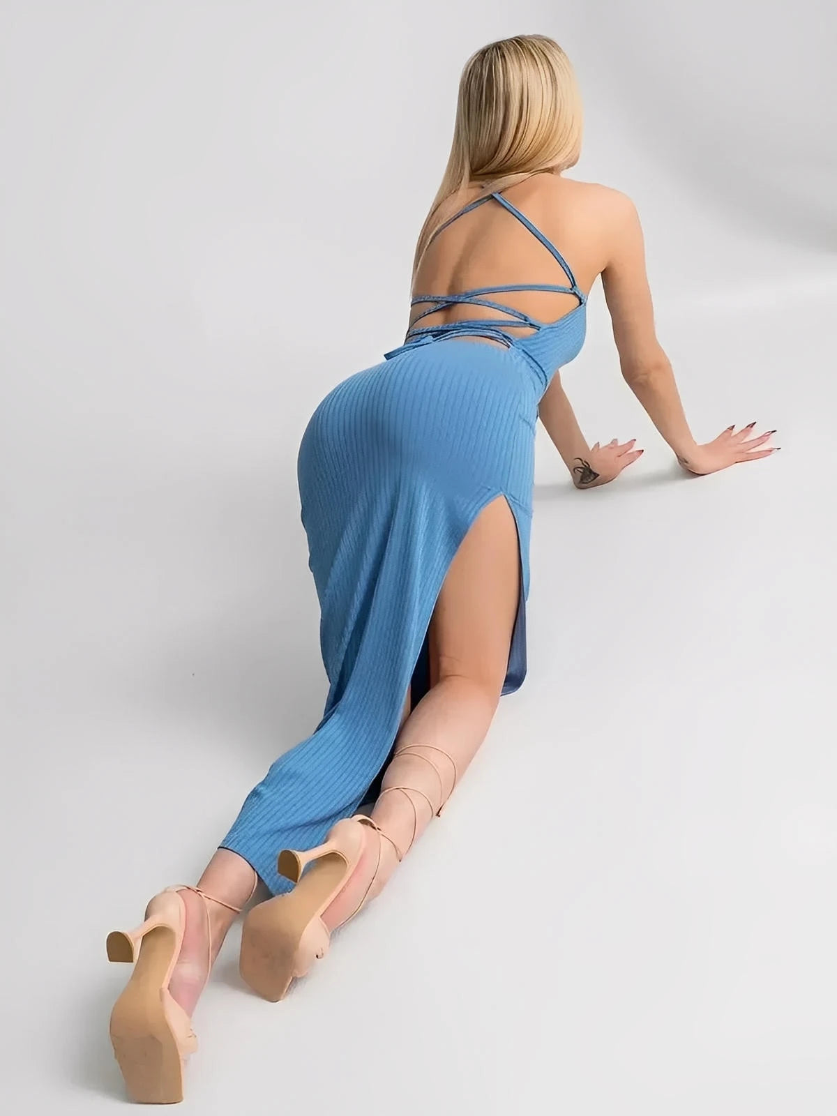 Woman in Ocean Lace Midi Dress showcasing ribbed knit, corset back, and bold side slit, ideal for summer elegance.