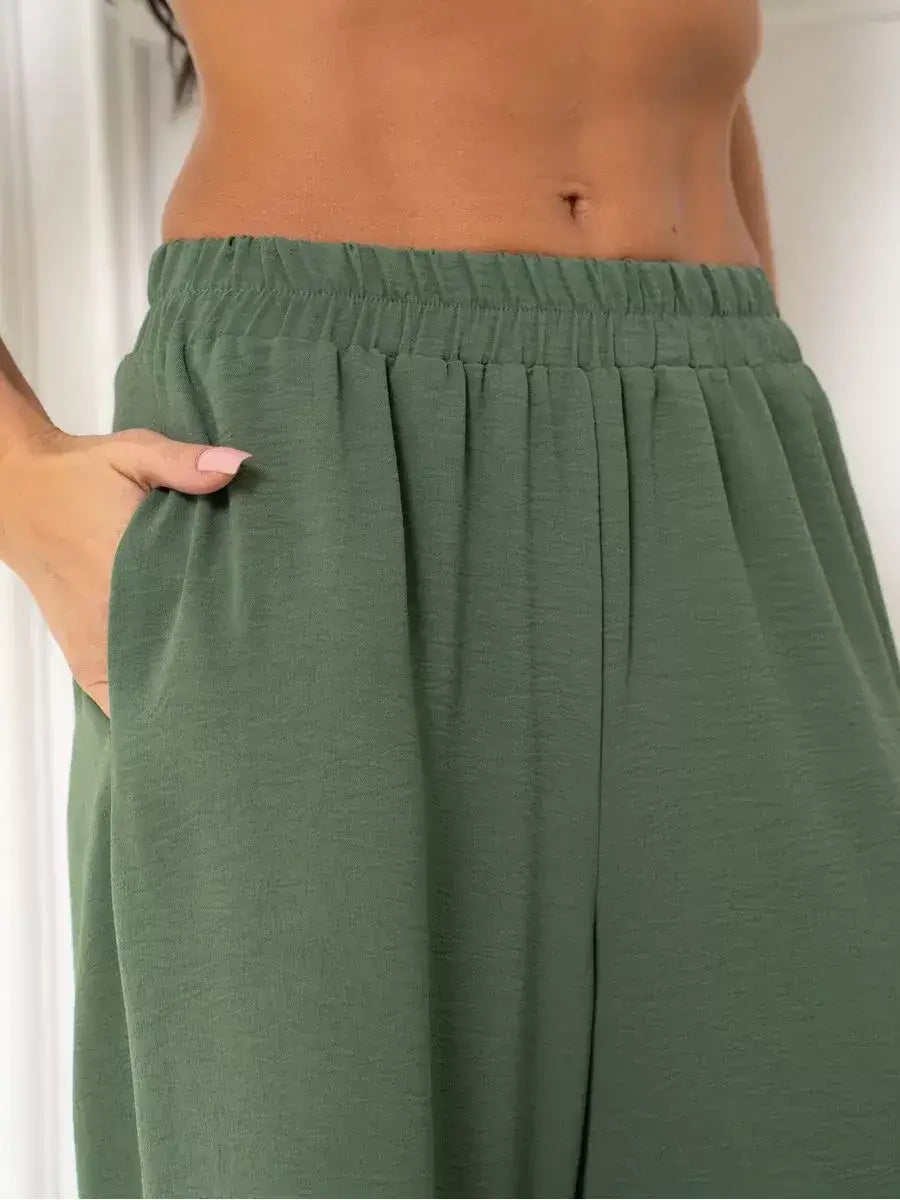 Close-up of Olive Suit Set wide-leg trousers showcasing side pockets by Lauven, crafted in soft green fabric.