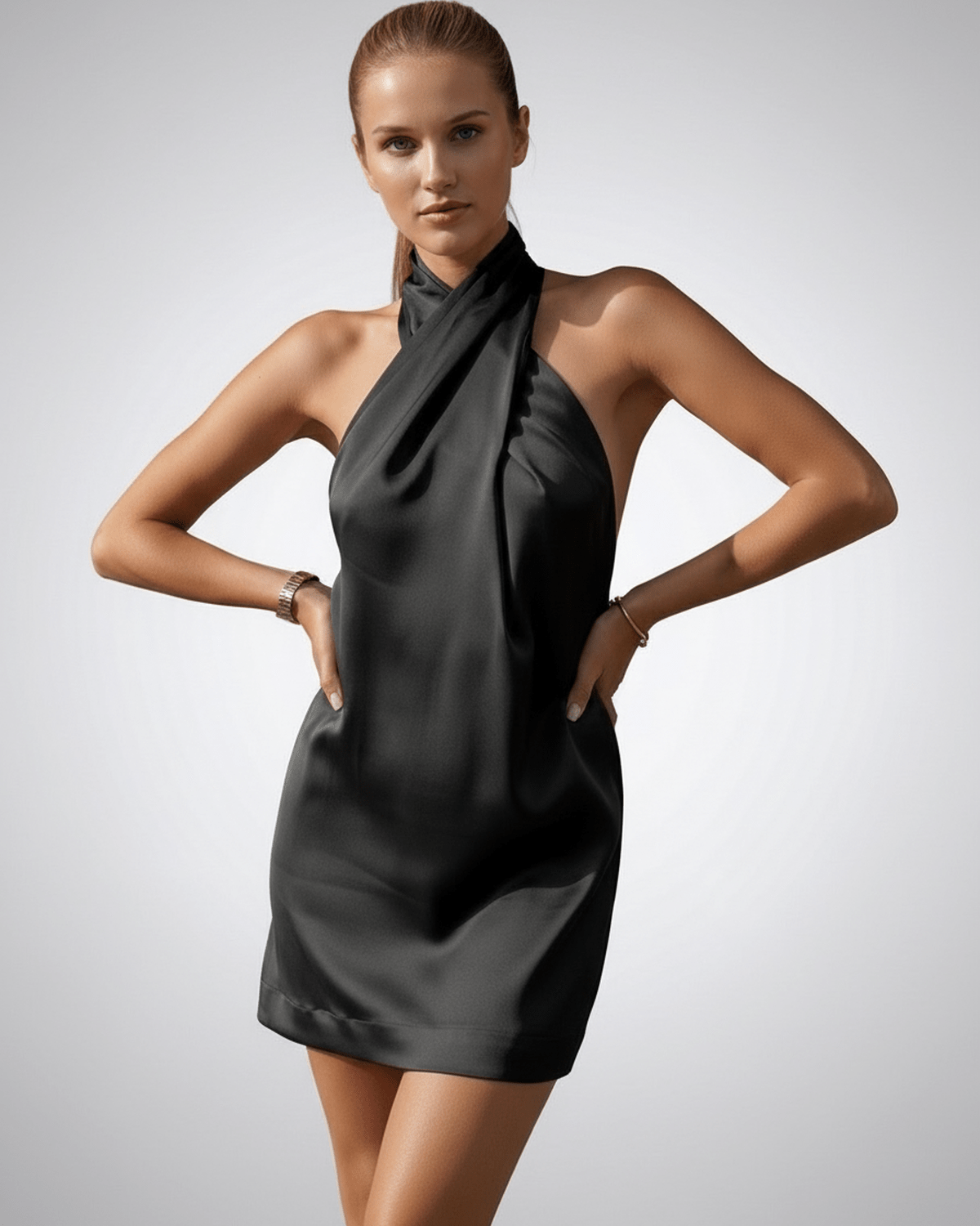 Onyx Mini Dress by Lauven, featuring a black satin fabric and a stylish halter neckline, showcasing a sleek silhouette.
