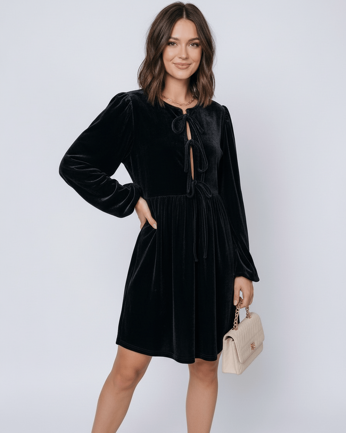 Onyx Mini Dress by Lauven, featuring a sleek black velvet design with drawstring detail and long lantern sleeves.