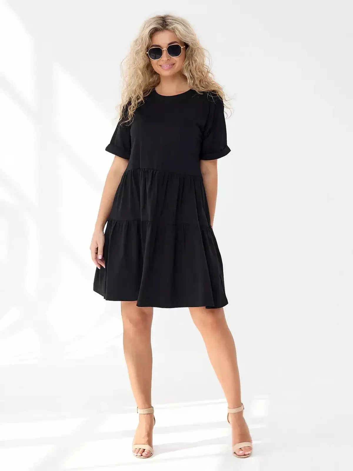 Model wearing a stylish black midi dress with a tiered silhouette, perfect for summer outings and casual occasions.