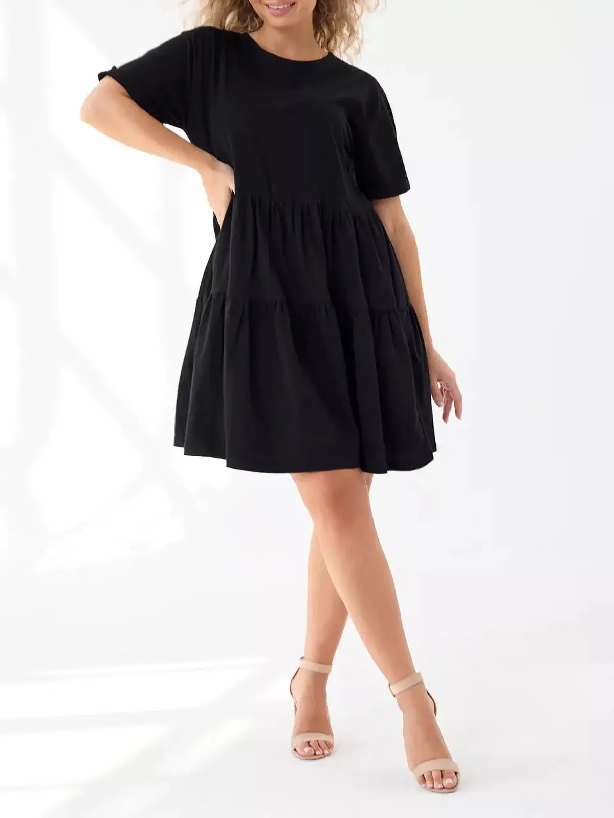 Black mini dress featuring a tiered silhouette, short sleeves, and a relaxed fit, perfect for summer and casual occasions.