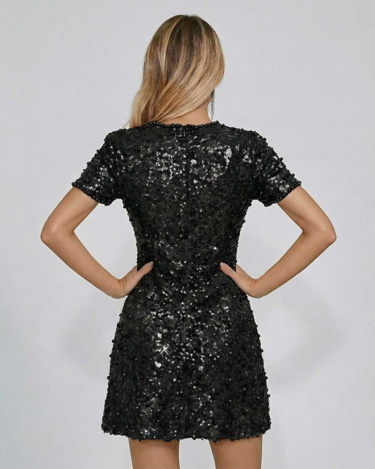 Back view of Nova Mini Dress by Lauven in classic black with sequins and short sleeves, showcasing elegant detailing.