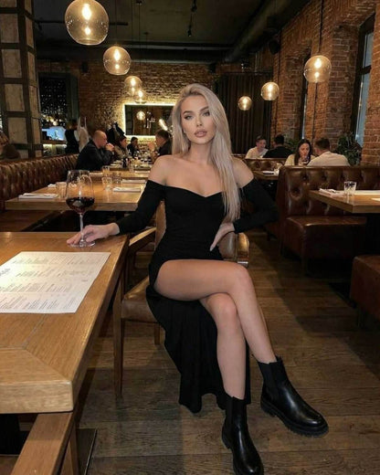 Noir Maxi Dress by Lauven — Off-the-shoulder slim fit worn in a stylish restaurant setting, showcasing elegance.