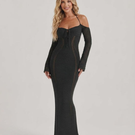 Model wearing Noir Maxi Dress, a black long sleeve bodycon gown with open back halter design by Lauven, showcasing elegant style.