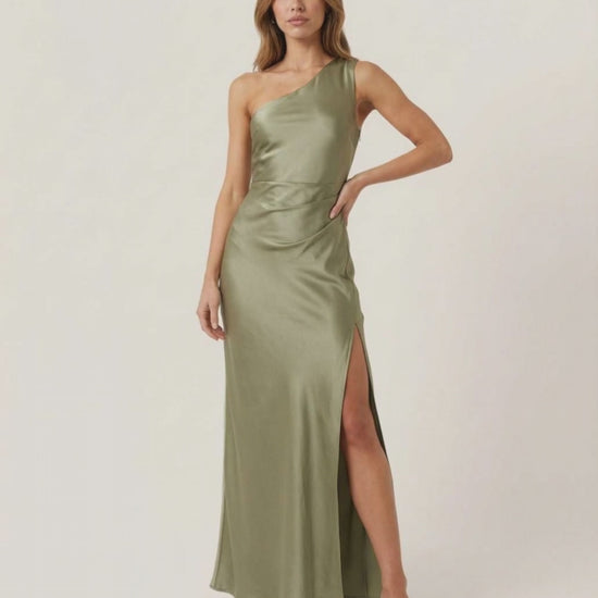 Solene Maxi Dress – One-shoulder satin dress in sage green with side slit, by Lauven, creating an elegant occasion look.