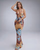 Model wearing a halter V-neck Lunara Maxi Dress in textured polyester blend, featuring a colorful ripple finish and stylish accessories.