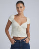 Model wearing Elara Tie Top by Lauven, a ruched V-neck crop blouse with adjustable tie detail.