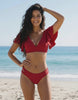 Lauven Riviera Two-Piece Swimsuit in red with deep V-neckline and flutter sleeves on beach.
