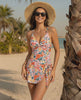 Solene One-Piece Swimsuit by Lauven features a floral design, twist-front neckline, and wrap-style skirt for stylish beachwear.
