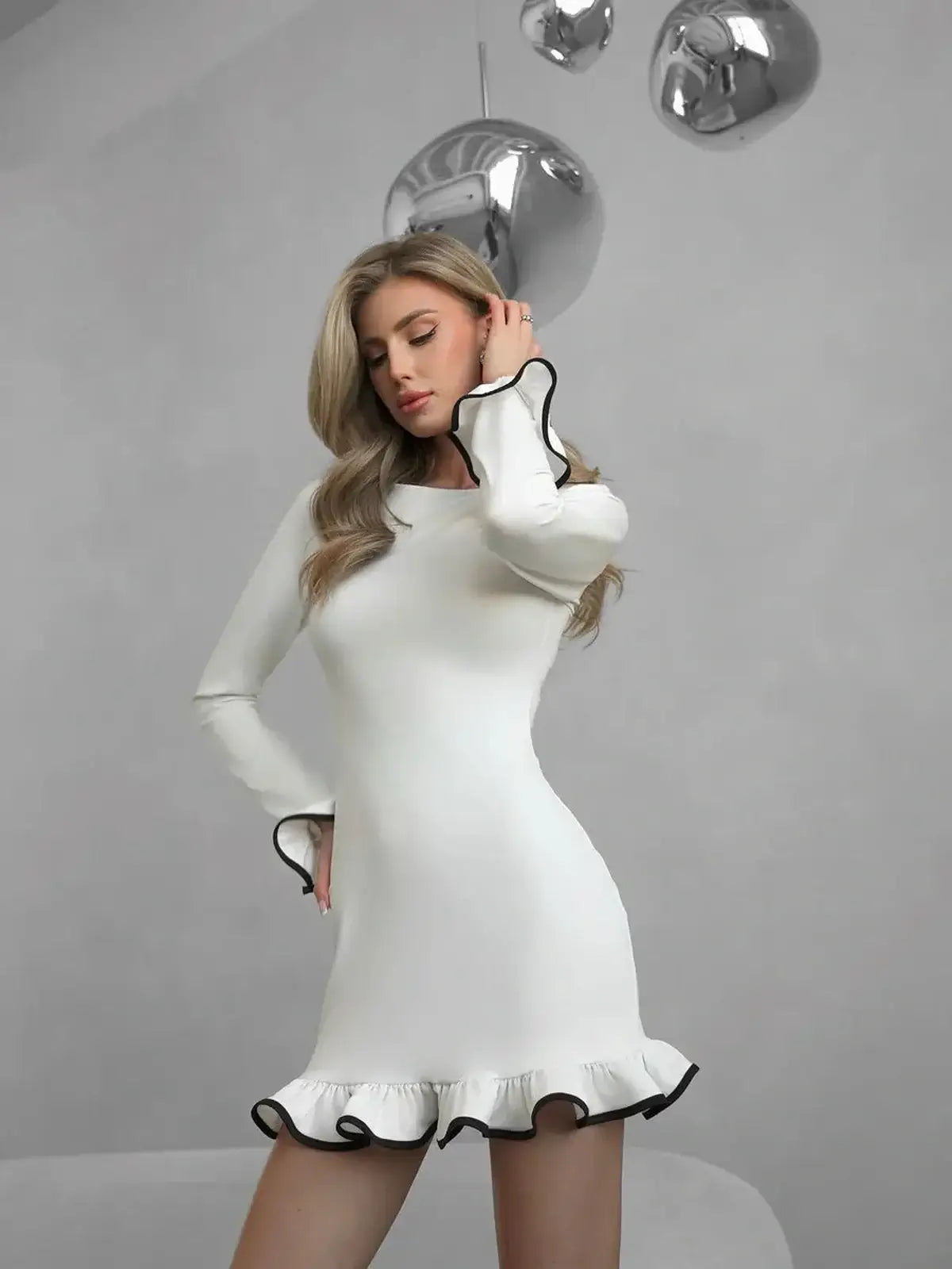 White mini dress with black ruffle trim, perfect for wedding guest dresses and formal occasions.