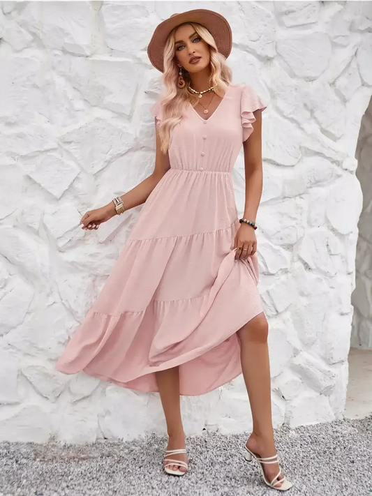 Woman in a pink midi dress with ruffled sleeves, perfect for summer or wedding guests, against a white backdrop.